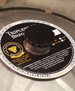 Custom printed 2 color keg collar placed on keg with black keg cap