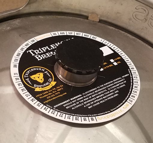 Custom printed 2 color keg collar placed on keg with black keg cap