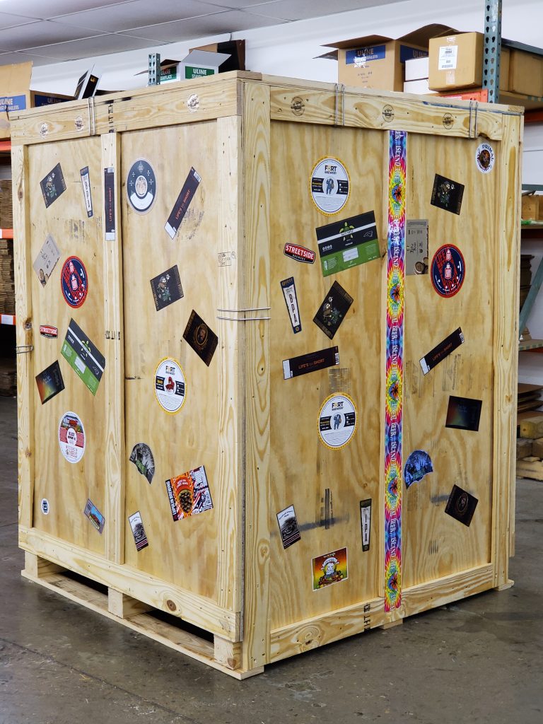 Crate we packed to ship our booth to show with stickers and keg collars all over it